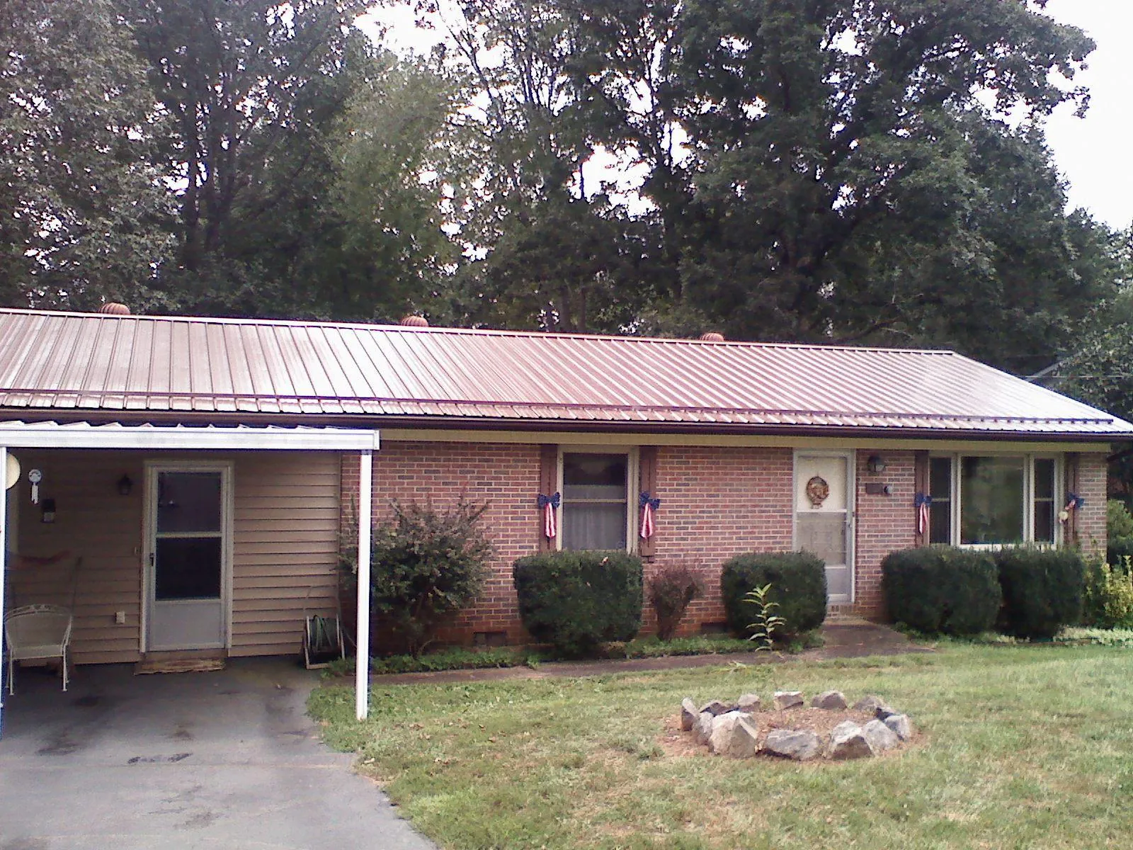 Bronze metal roof and carport on a brick ranch home — Roof Repair work by our crew in Mckenna