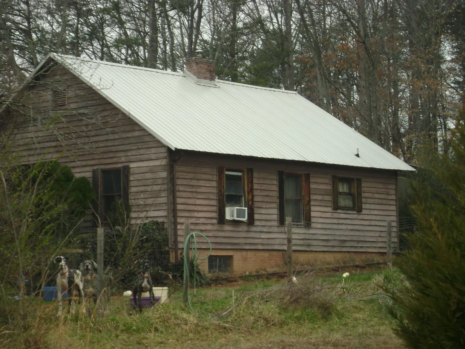 White metal roof on an old wood sided farmhouse, from a Metal Roof Installation job in Mckenna